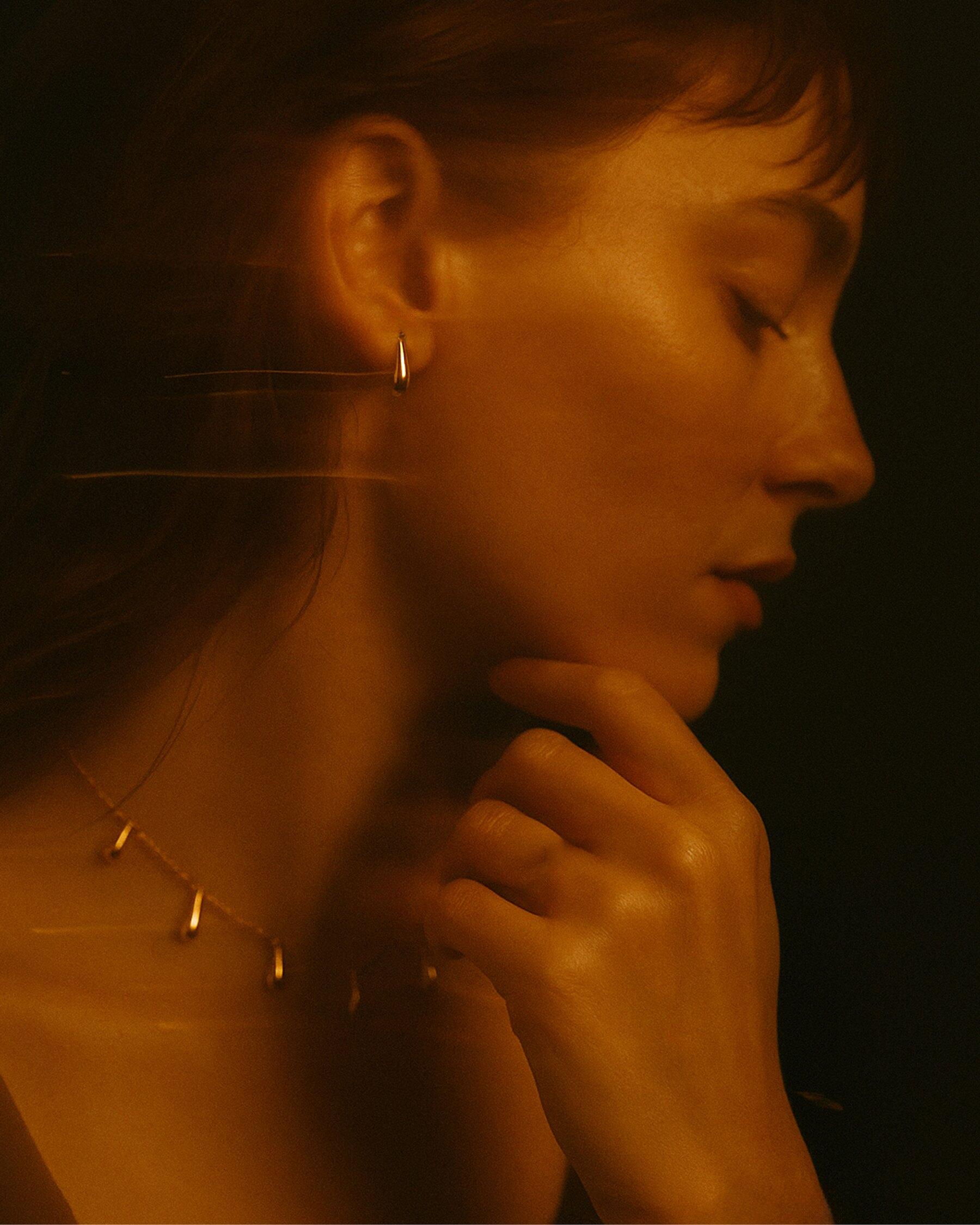 An Armarium gold drop earring and necklace, worn